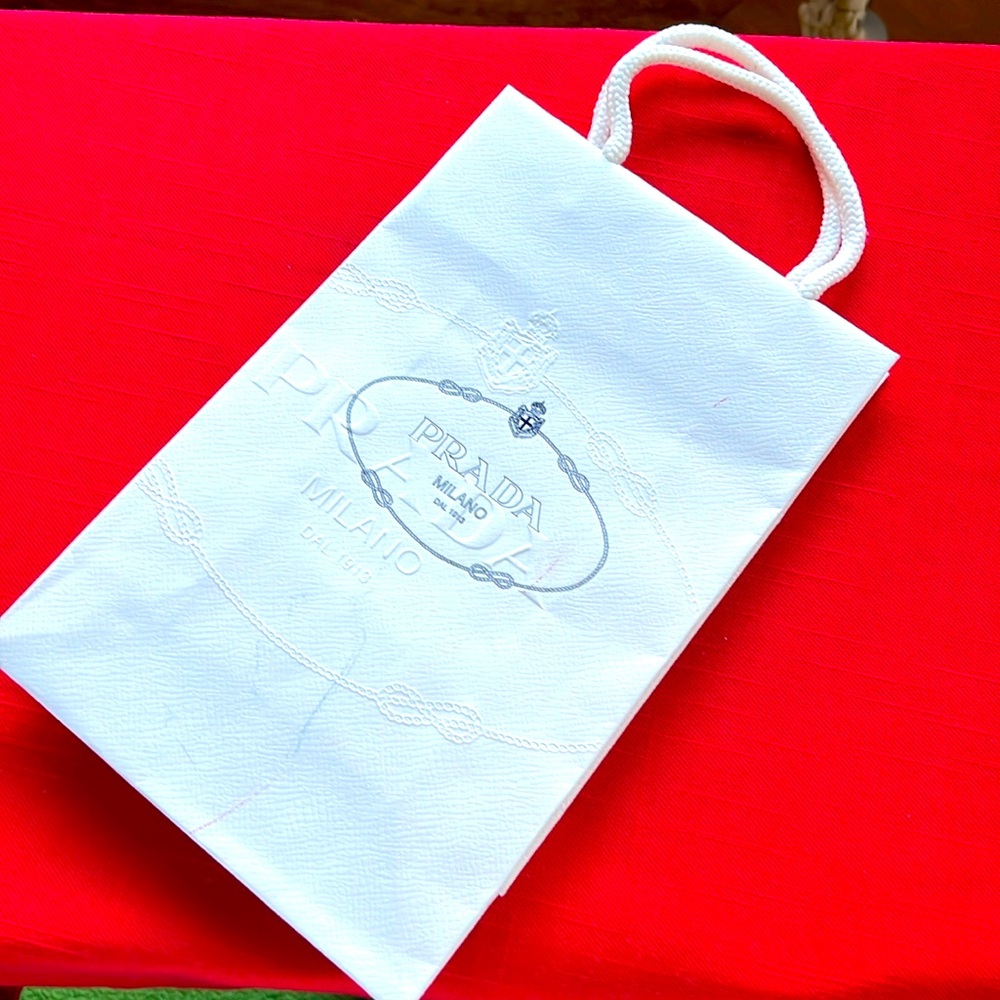 Paper PRADA gift bag. White with blue logo.